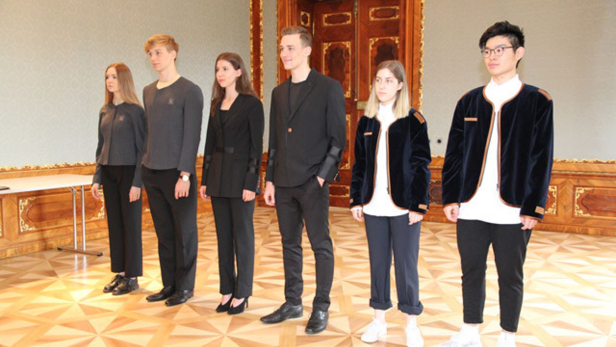 SchülerInnen tragen Prototypen von 3 Outfits