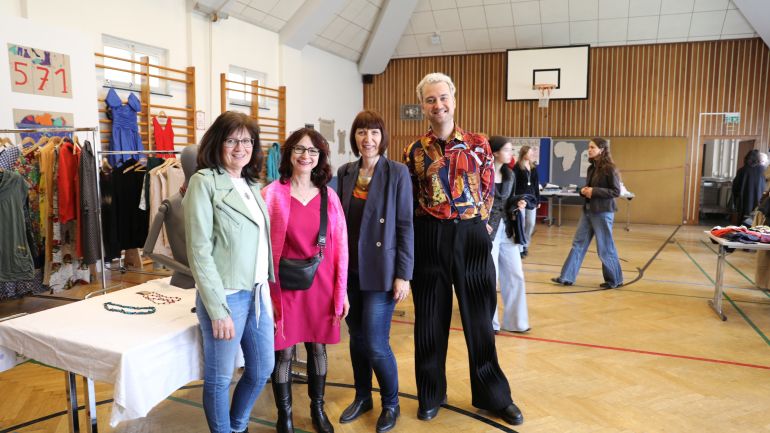copyright: Modeschule Hetzendorf 3 Frauen und 1 Mann in einem Turnsaal bei einem Verkaufstisch