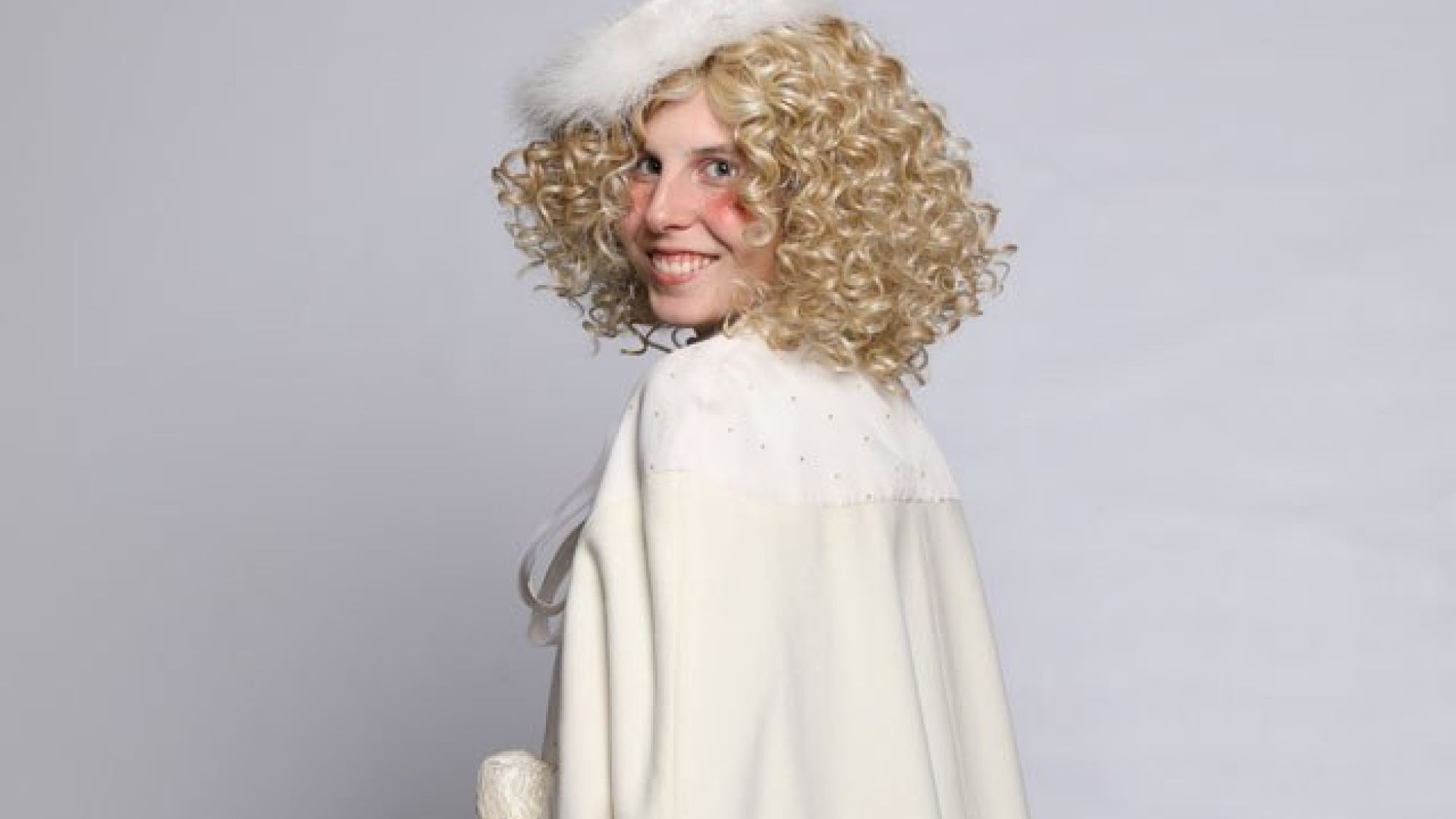 Frau mit goldenen Locken, weißem Umhang und weißem Hut