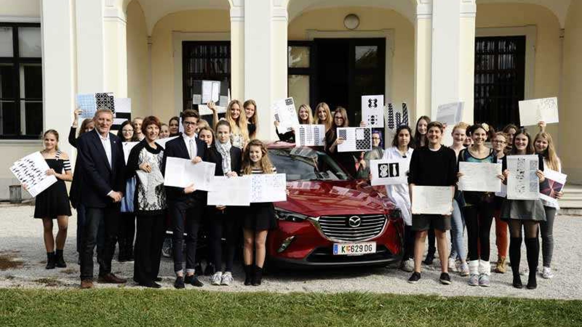 copyright: Stefanie Starz SchülerInnen mit Skizzenblöcken rund um Mazda-Wagen