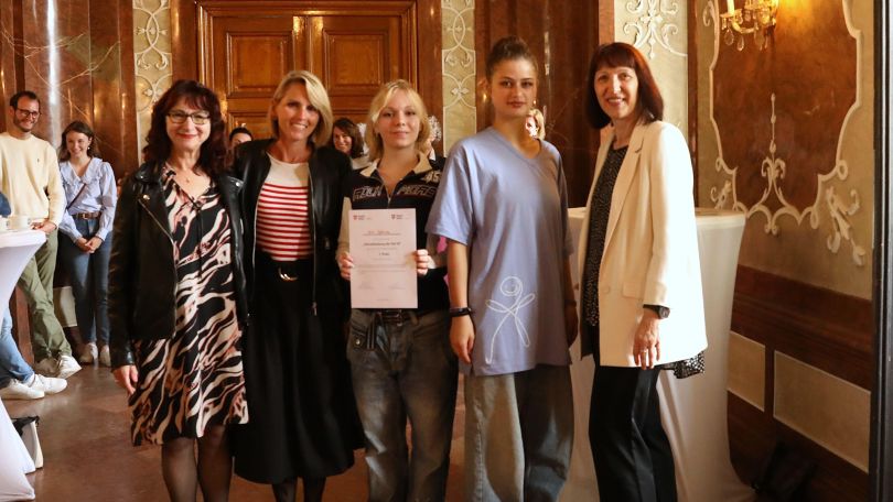 Gruppenfoto, in der Mitte eine Schülerin mit Zertifikat in der Hand.
