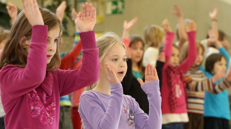 Kinder klatschen zur Musik.