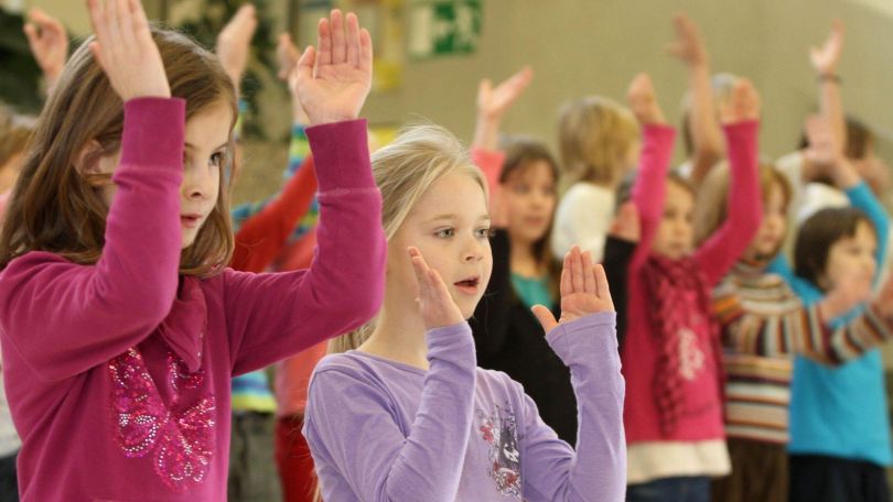 Kinder klatschen zur Musik.