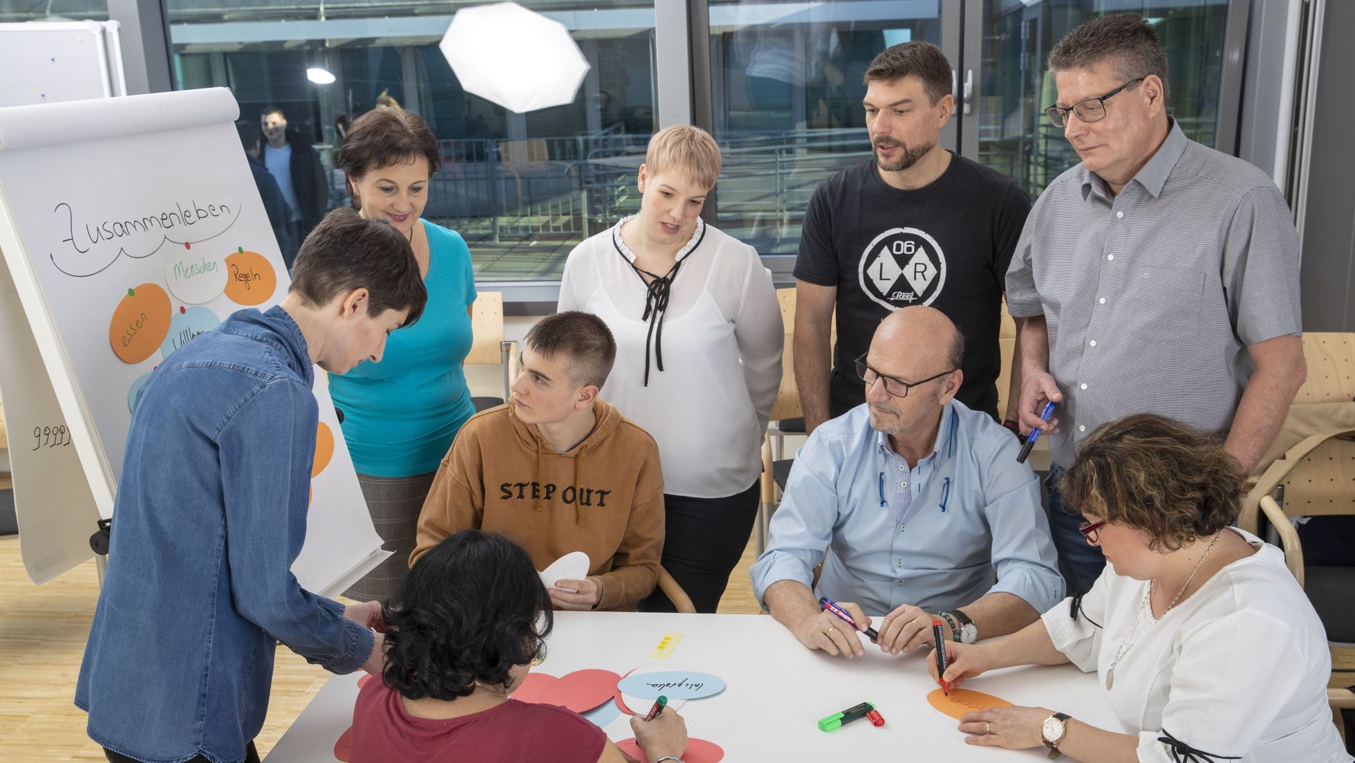 Gruppe von Personen sitzt an einem Tisch und erarbeitet ein Thema