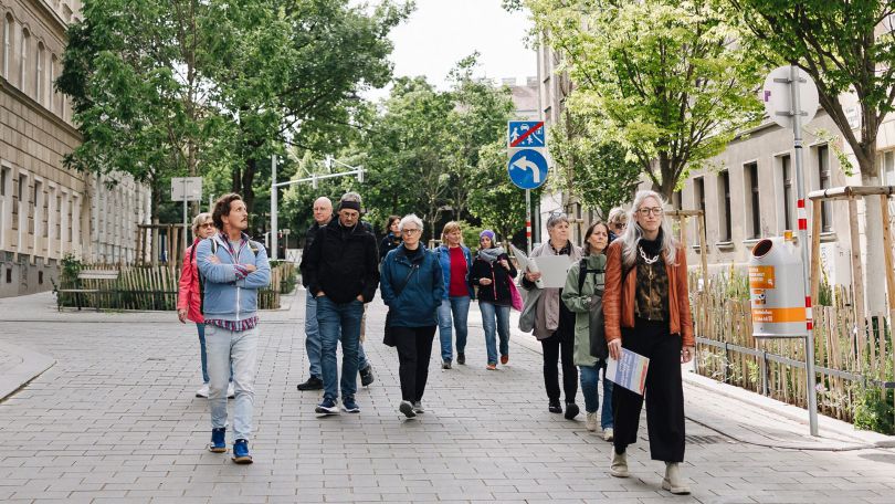 Eine Gruppe Menschen spaziert durch eine Straße.