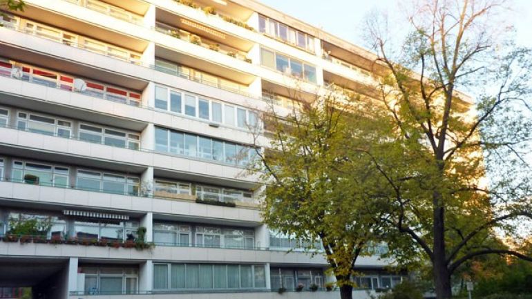 Fassadenansicht, horizontal gegliedert durch Fensterbänder, teilweise loggienartig als Rücksprünge ausgebildet