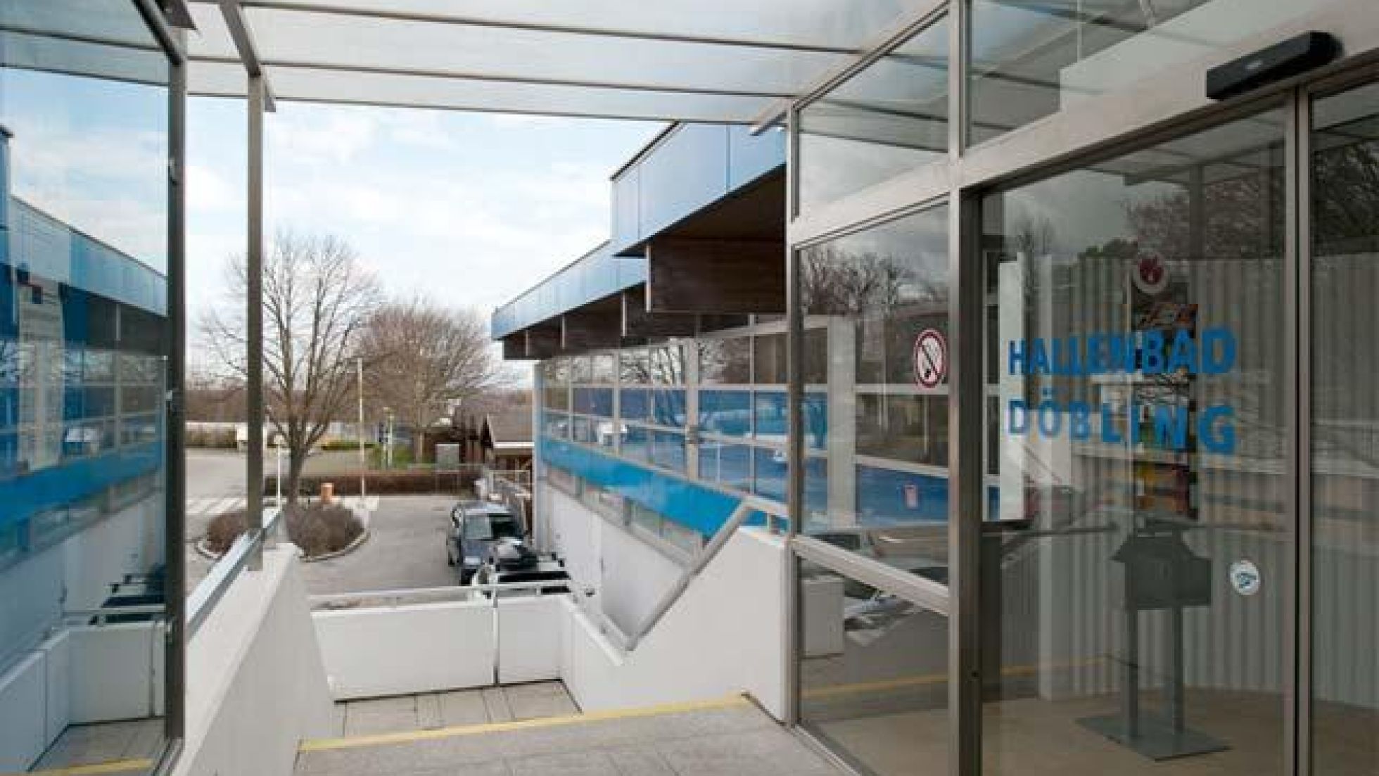 copyright: Fotografin: Pez Hejduk Stiegenabgang, links Glaswand, rechts Glastür mit Aufschrift "Hallenbad Döbling"