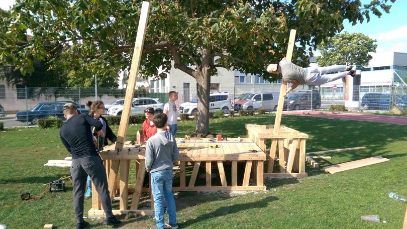 Junge Menschen beim Aufbau eines Holzgestells