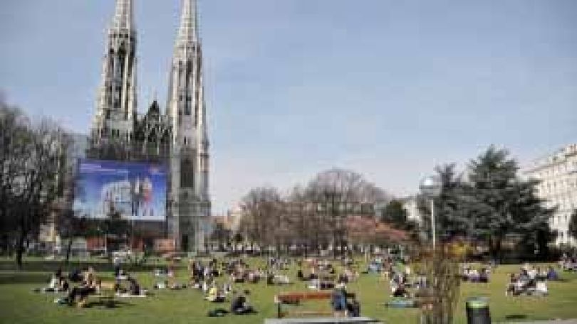 Votivpark im Sommer, viele Menschen liegen im Park in der Sonne