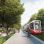 Visualisierung einer Straßenbahn auf Grüngleisen, daneben ein 2-Richtungsradweg, Bäume und ein Gehweg.