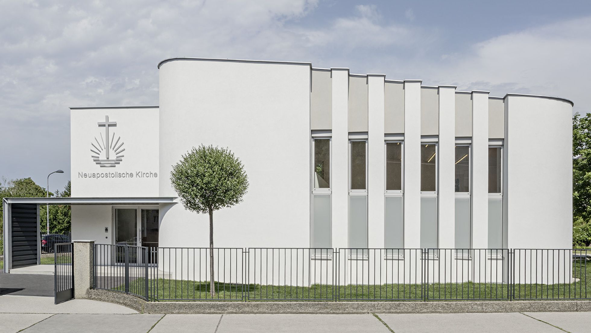 Moderne weiße Kirche mit Vordach und schmalen