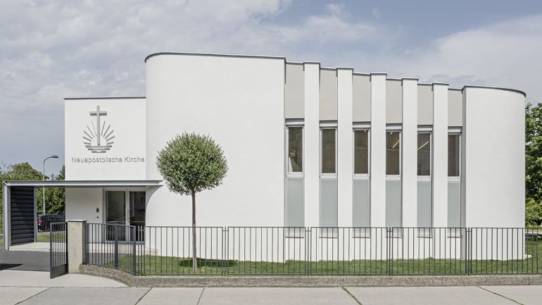 Moderne weiße Kirche mit Vordach und schmalen