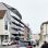 Dunkelsilberne Fassade mit Balkonen und Dachterrasse