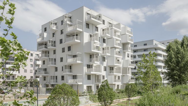 Mehrstöckiges weißes Wohngebäude mit Balkonen