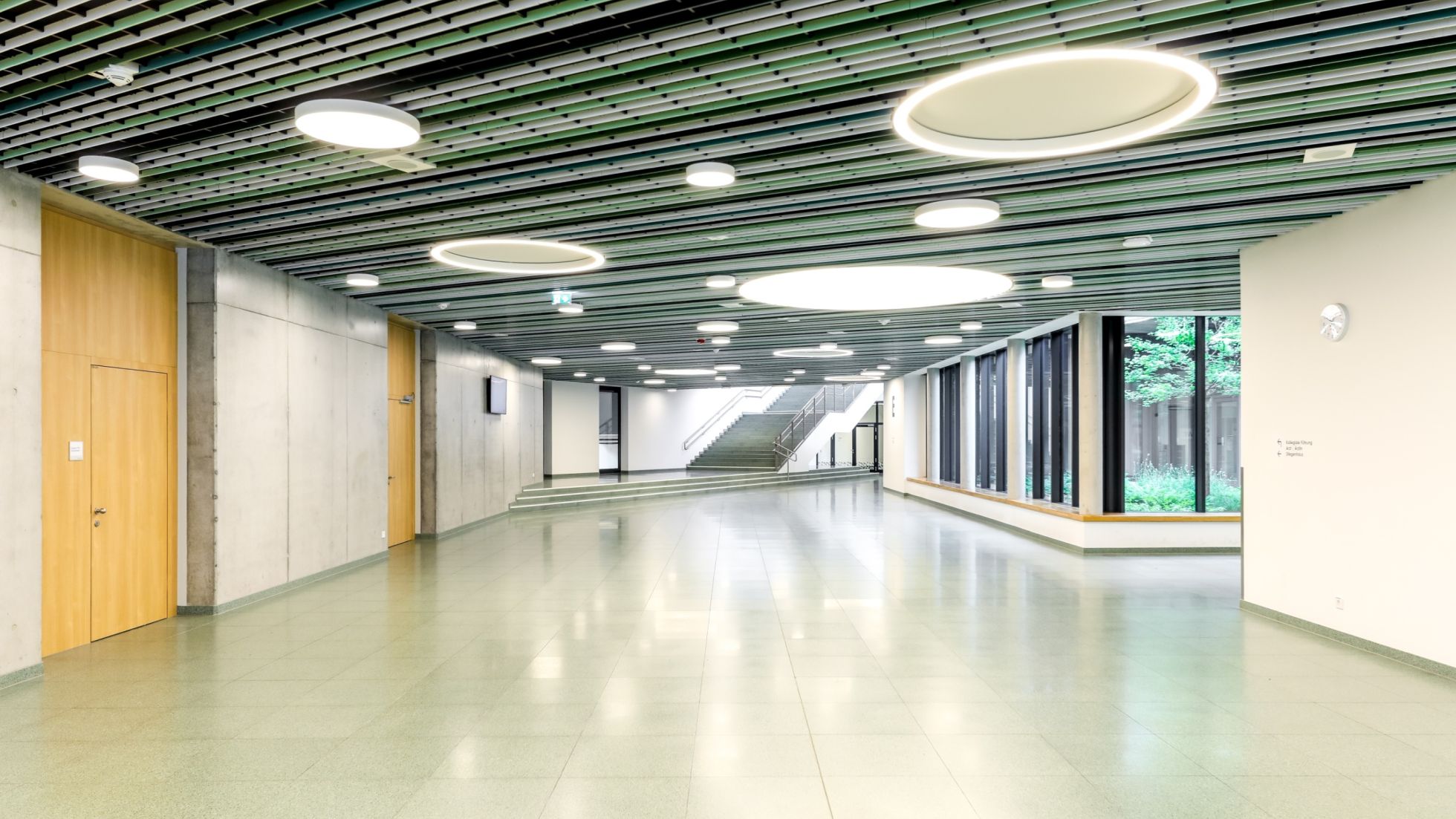 Breiter Gang mit Glasfassade Richtung Innenhof