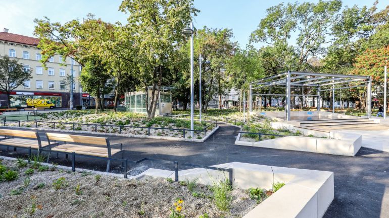 copyright: PID/Christian Fürthner Platz mit vielen Pflanzen, Sitzbänken und einer Freiluftbühne