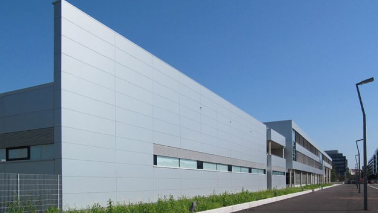 langgestrecktes Gebäude mit Fensterbändern und einer mit Aluminiumplatten verkleideten Fassade