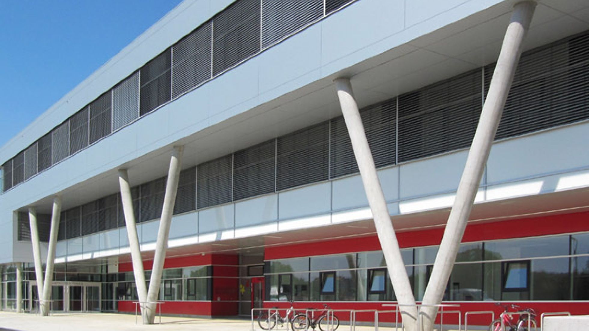 3 V-Stützen halten Obergeschoß eines langgestreckten Baukörpers