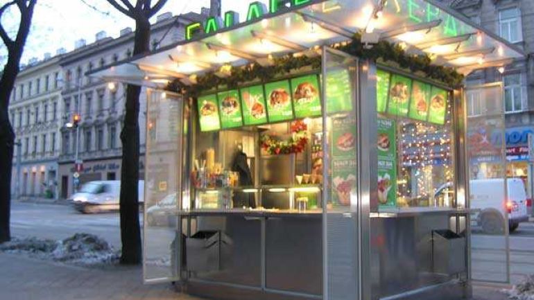 Ein beleuchteter Kebabkiosk aus Alu mit transparentem Vordach,drei Windschürzen und zwei Alumüllbehälter