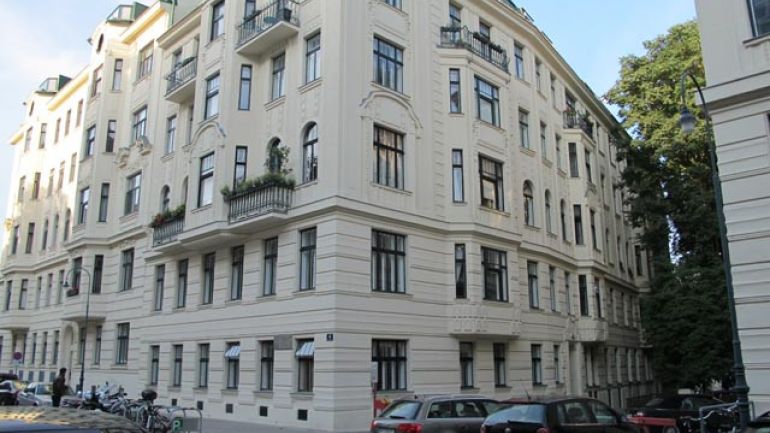 Mehrgeschossiges Eckhaus, Blick von unten, neben und über den Erkern befinden sich historisierende  Balkone