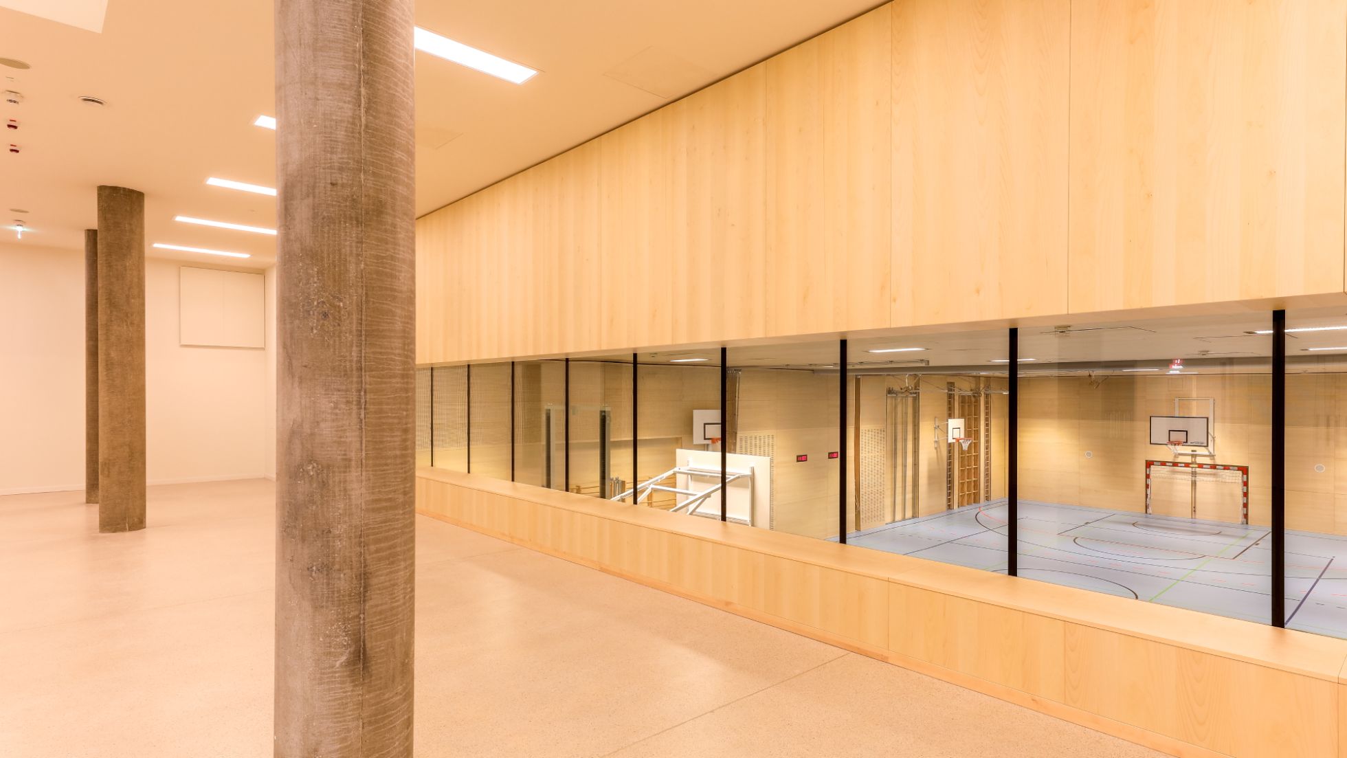 Aula mit Blick auf Turnsaal, Glas, Holz