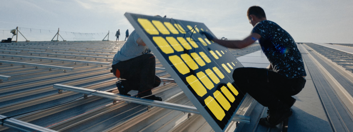2 Männer montieren eine Solaranlage auf einem Dach
