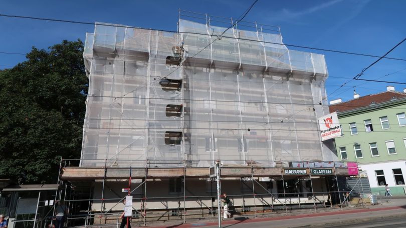 Hausfassade mit Gerüst und Plane