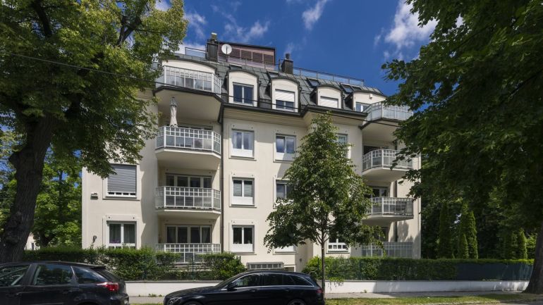 Zinshaus mit Balkonen, rundum Bäume