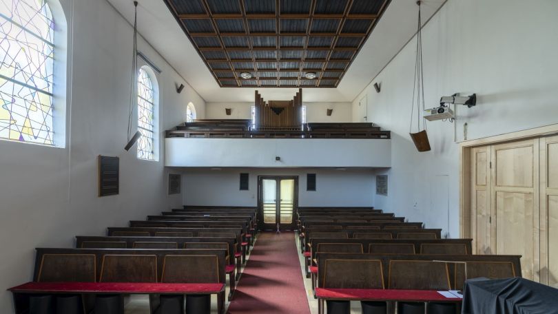 Innenraum einer Kirche mit Sitzbänken und Orgel