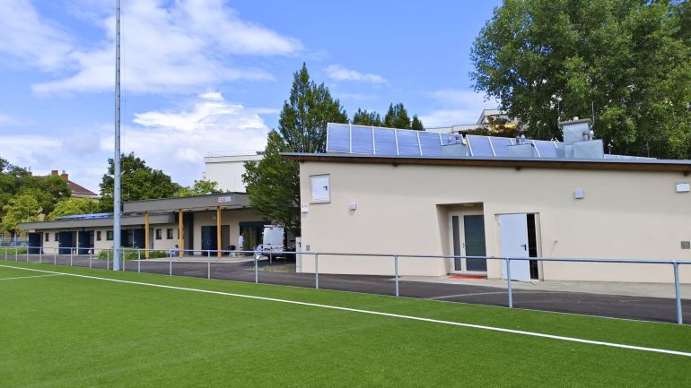 Sportanlage mit Rasenfläche und Gebäude