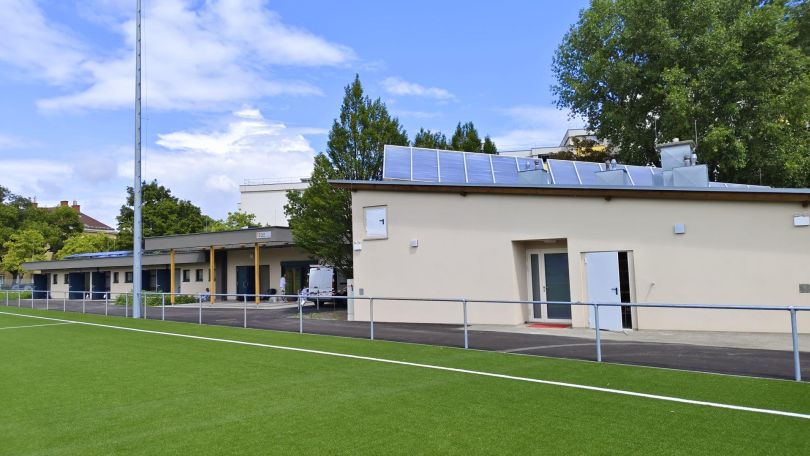 Sportanlage mit Rasenfläche und Gebäude