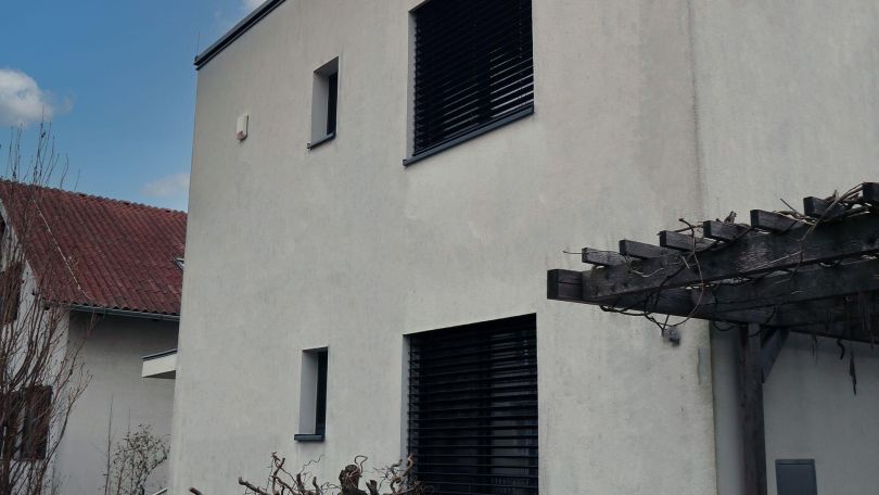 Einfamilienhaus mit Luftwärmepumpe und Pflanzen