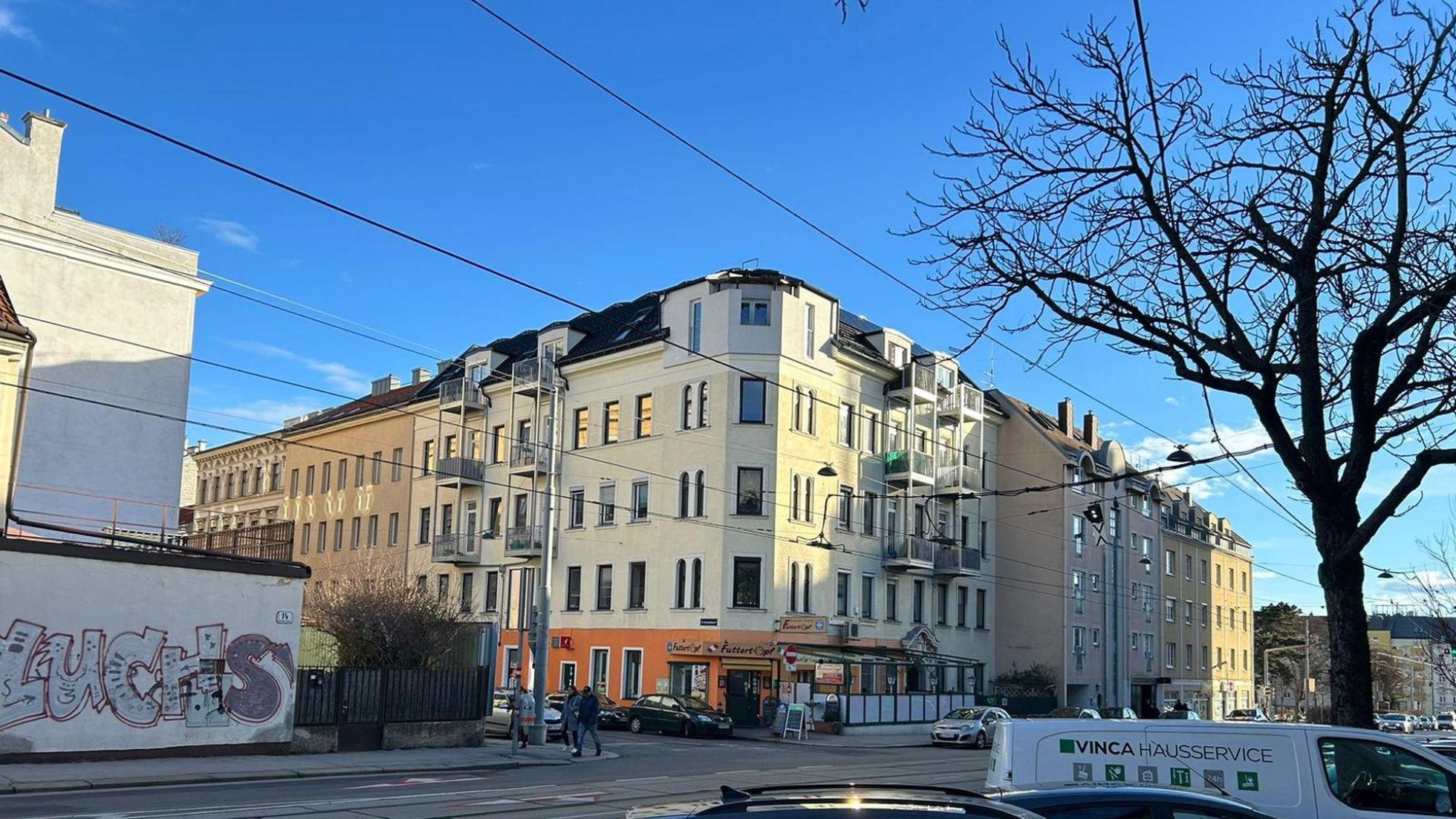 copyright: Büro für Erneuerbare Energie - Ing. Leo Riebenbauer GmbH Eckansicht eines mehrgeschoßigen Wohnhauses, davor Straße und Autos