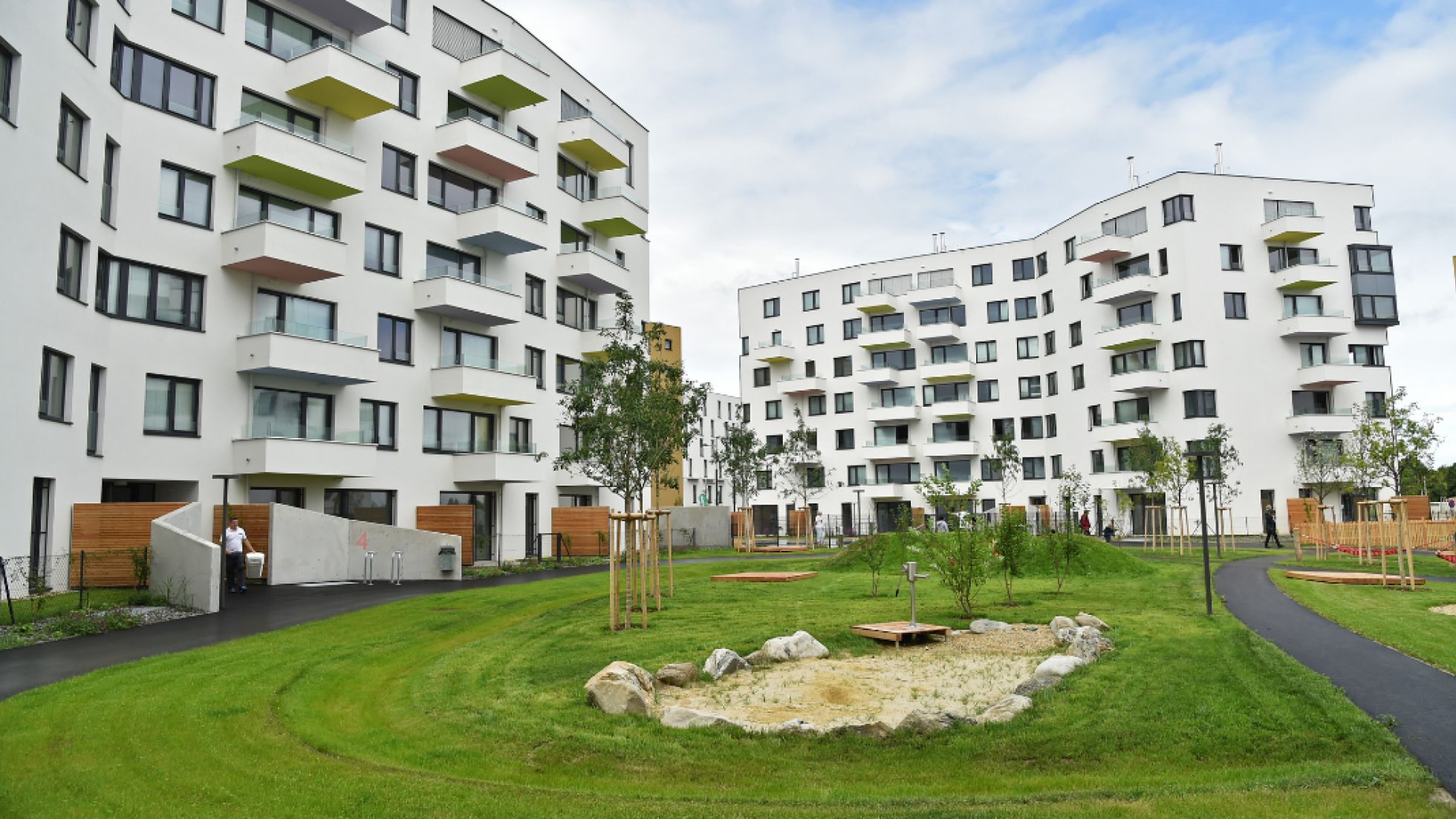 Zwei Wohngebäude mit Balkonen, begrünter Innenhof mit Bäumen