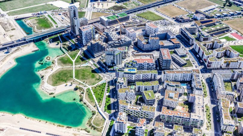 Luftbildaufnahme See und Wohngebäude in der Seestadt