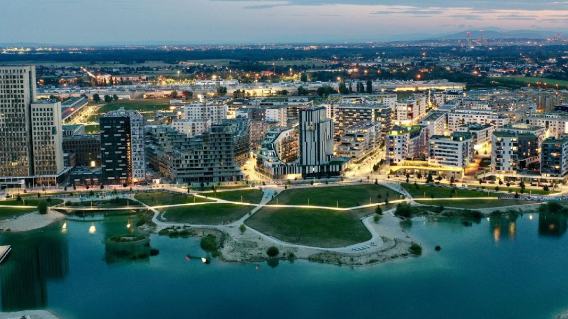 Schrägluftbild von der Seestadt in der Dämmerung, beleuchtet