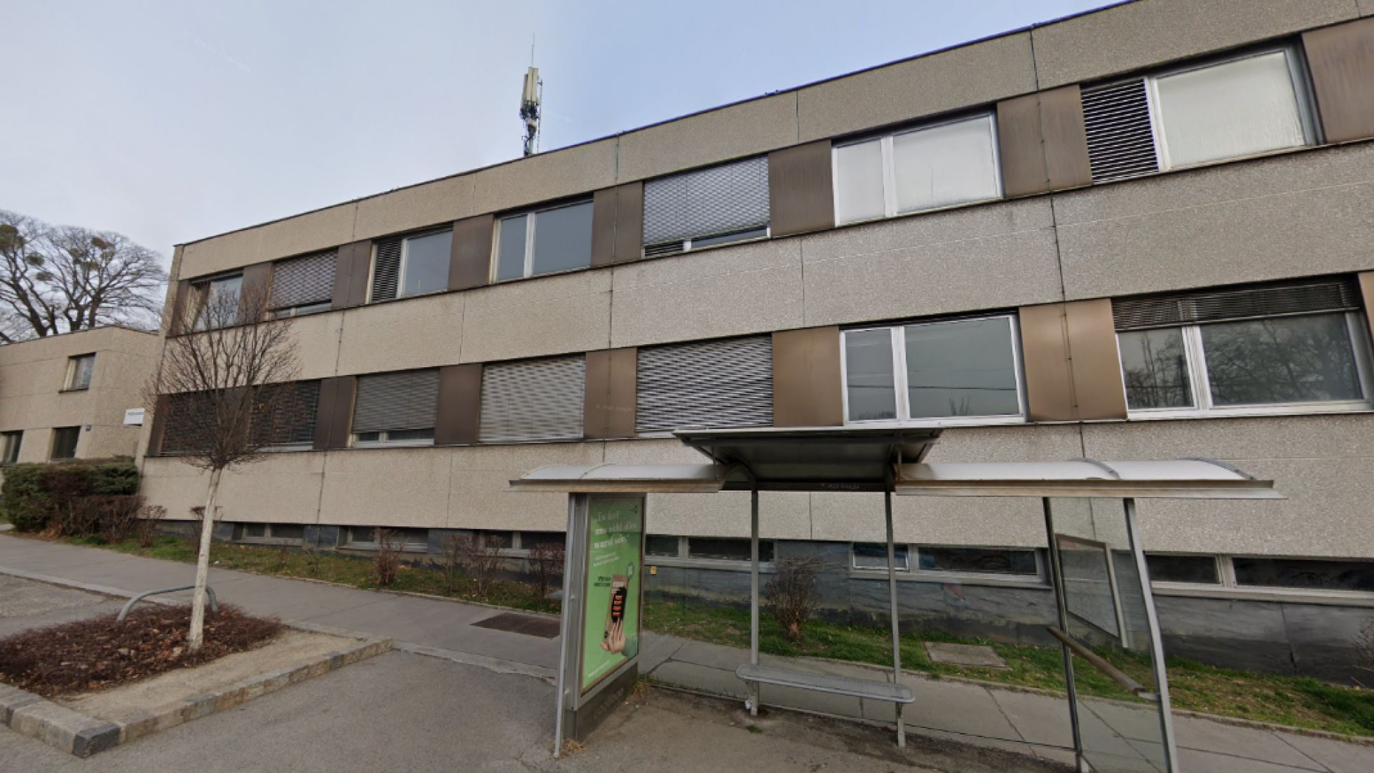 Altes Bürogebäude, davor Autobushaltestelle