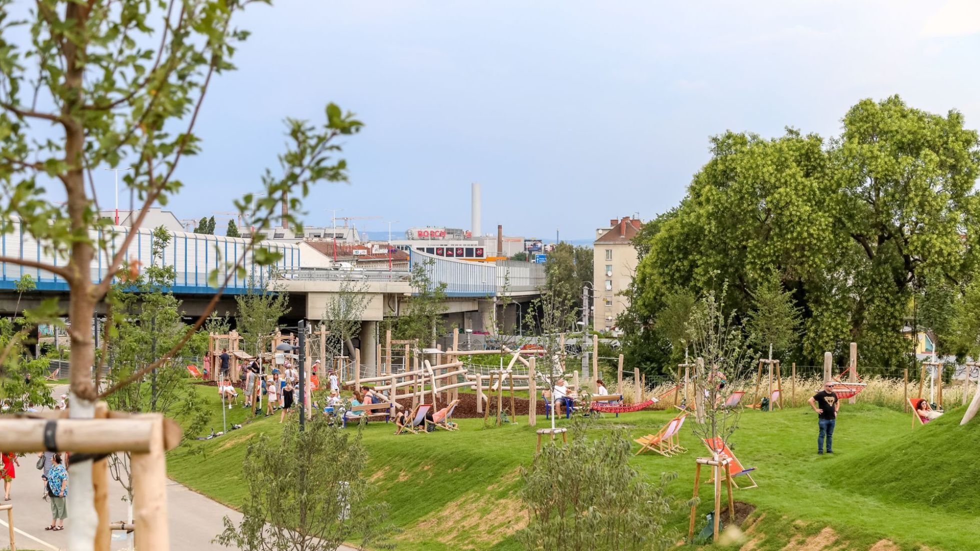 copyright: Stadt Wien/Christian Fürthner Grünraum mit Wiese, Bäumen, Sitzgelegenheiten und Spielplatz