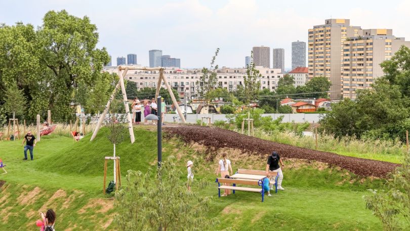 Erholungsraum mit Bäumen, Wiese, Sitzgelegenheiten und Spielplatz