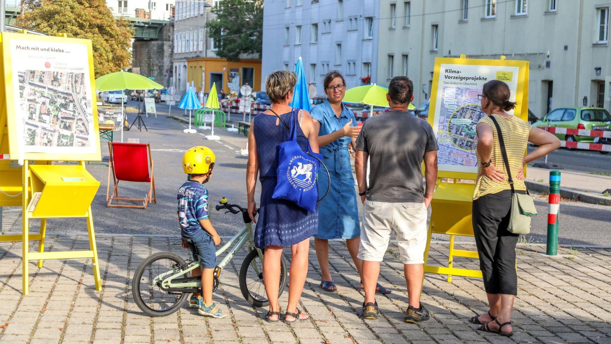 Erwachsenen und Kind auf Fahrrad werden über das Projekt informiert.