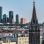 copyright: Stadt Wien / Gerd Götzenbrucker Links im Hintergrund eine Skyline mit verglasten Hochhäusern, rechts vorne 2 Kirchtürme, dazwischen Stadtgebiet.