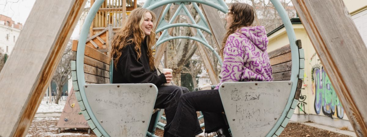 2 Mädchen sitzen in einer großen Schaukel.