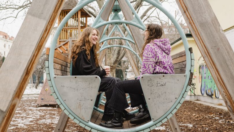 2 Mädchen sitzen in einer großen Schaukel.