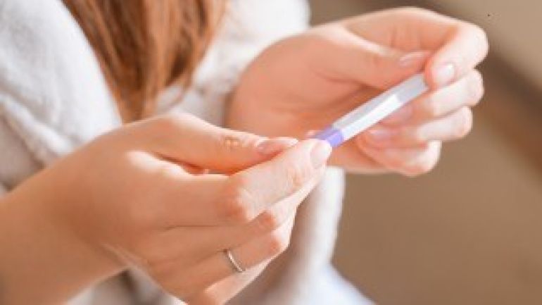 Frauenhände halten Schwangerschaftstest