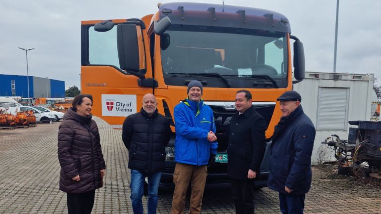 Violeta Tanackovic (MA 27), Robert Neumayr (MA 48), Bernhard Bouzek (MA 27), Bürgermeister Zlatko Siljanoski (Debrca) und ein Dolmetscher stehen vor einem Müllsammelfahrzeug  der MA 48