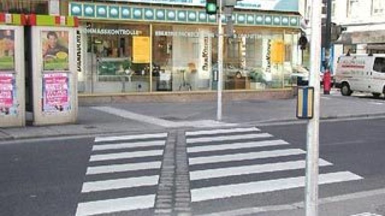Blindenleitsystem für blinde und sehbehinderte Menschen auf einer Straßenkreuzung