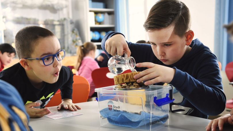 Zwei Schüler experimentieren mit Wasser