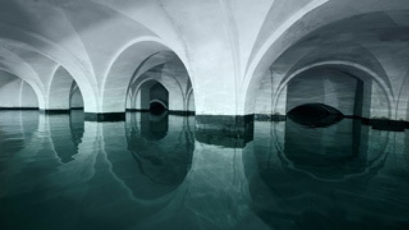 Ruhiges Wasser ein einem riesigen Wasserbehälter mit einer Gewölbedecke.