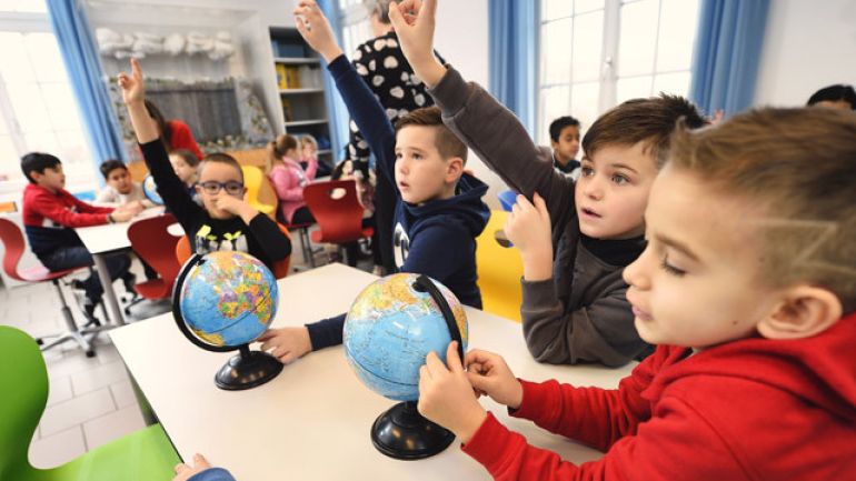 Buben in einer Schulklasse zeigen auf