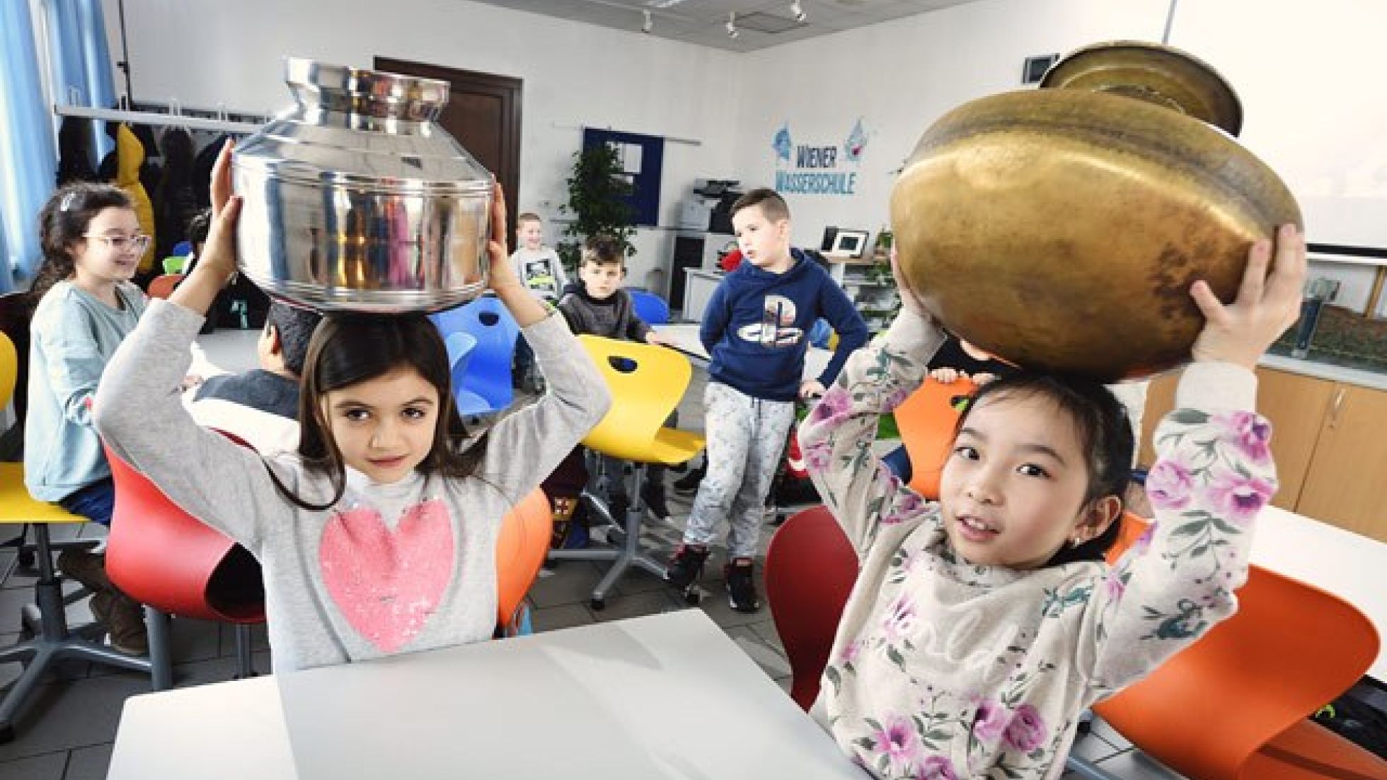 Mädchen balancieren einen Wasserkrug auf dem Kopf